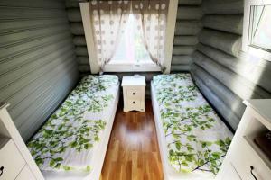 a small room with two beds and a window at Beautiful riverside cottage with sauna in Nuorgam