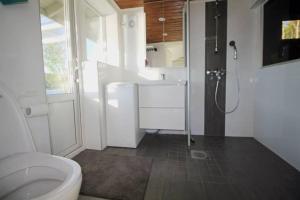 Un baño con inodoro, lavabo y ducha. en Beautiful riverside cottage with sauna, en Nuorgam 19 fotos más