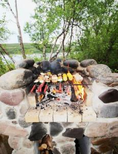 a stone grill with food on top of it at Beautiful riverside cottage with sauna in Nuorgam