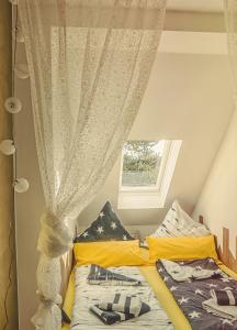 1 dormitorio con 2 camas y ventana en Goldrausch - Glanzvolle Ferienwohnung in Meißen am Lutherplatz, en Meißen