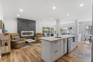 a kitchen and living room with a couch and a table at Halls Head Haven in Mandurah