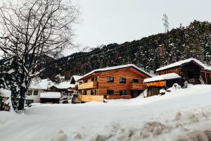 domek z bali na śniegu pokryty śniegiem w obiekcie Haus Riefli- Monique w mieście Sankt Anton am Arlberg