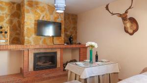 a living room with a fireplace and a tv on a wall at Villa Ortega Alba Alcalá La Real by Ruralidays in Alcalá la Real