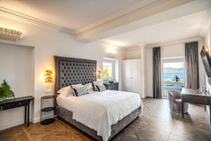 a bedroom with a bed and a desk and a window at Vigna Caio Relais & Spa in Bracciano