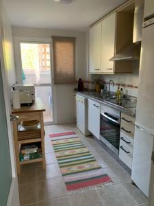uma cozinha com armários brancos e um forno com placa de fogão em Casa Elsi Prachtig vernieuwd appartement em Manilva