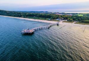 an aerial view of a pier in the water with a beach at Ferienwohnung Seepferdchen direkt am Strand in Ostseebad Koserow