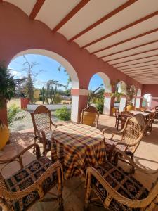 a patio with a table and chairs and windows at Finca exclusiva (10.000m2) para 10-17 personas in Seville