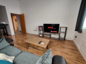 a living room with a couch and a tv at Pass the Keys Spacious Apartment Minutes to Birmingham Centre in Birmingham