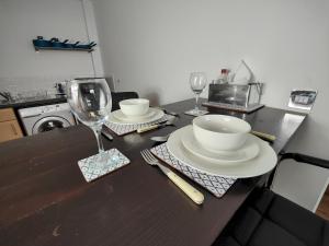 a kitchen counter with a table with plates and glasses at Pass the Keys Spacious Apartment Minutes to Birmingham Centre in Birmingham