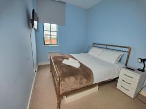 a bedroom with a bed and a blue wall at Pass the Keys Spacious Apartment Minutes to Birmingham Centre in Birmingham