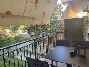 a table and chairs on a balcony with an umbrella at Apartment by the castle in Ioannina