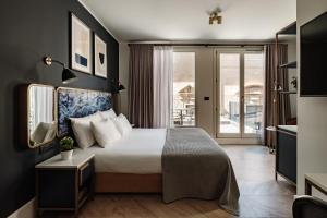 a hotel room with a bed and a balcony at The Cumberland Hotel by NEU Collective in Valletta