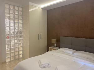 um quarto com uma grande cama branca e uma janela em Apartment by the castle em Ioannina