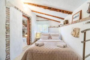 um quarto com uma cama grande num quarto com paredes brancas em Holiday Home Gabelot em Supetar
