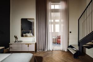 sypialnia z łóżkiem i lustrem w obiekcie The Cumberland Hotel by NEU Collective w mieście Valletta