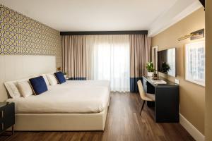 a hotel room with a bed and a desk at 115 The Strand Hotel by NEU Collective in Il-Gżira