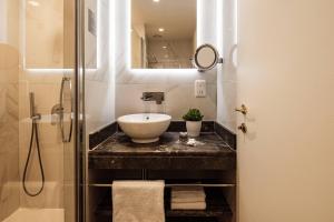 a bathroom with a sink and a mirror at 115 The Strand Hotel by NEU Collective in Il-Gżira