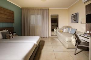 a hotel room with a bed and a couch at 115 The Strand Hotel by NEU Collective in Il-Gżira