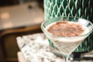 a drink in a martini glass sitting on a counter at 115 The Strand Hotel by NEU Collective in Il-Gżira