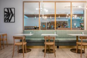 a restaurant with tables and chairs and a counter at 115 The Strand Hotel by NEU Collective in Il-Gżira