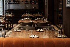 a long table in a restaurant with glasses and napkins at 115 The Strand Hotel by NEU Collective in Il-Gżira