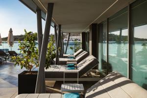 a balcony with couches and a view of the water at 115 The Strand Hotel by NEU Collective in Il-Gżira