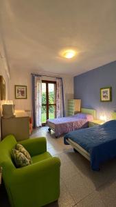 a bedroom with two beds and a green couch at Immobiliare Al Ponte in Cavallino-Treporti