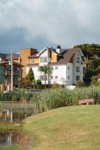 a group of houses and a pond in a park at Lindo apartamento recém inaugurado em Gramado in Gramado