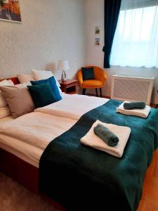 - une chambre avec un grand lit et des serviettes dans l'établissement Rossalini Apartment with FREE Parking, à Budapest