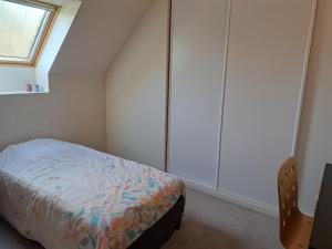 een slaapkamer met een bed en een raam bij Au Chat Perché espace familial in Mareil-sur-Mauldre