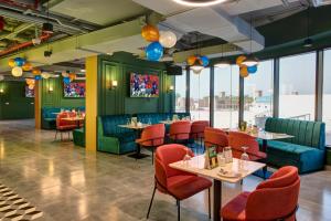 a restaurant with green walls and red chairs and tables at Wescott Hotel in Dubai +51 photos