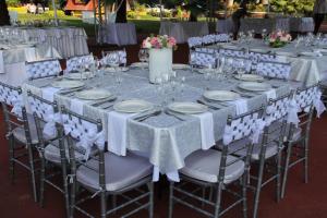 un conjunto de mesas con manteles y sillas blancas en Hotel La Villa Real, en Cuautla Morelos