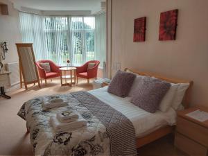a bedroom with a bed and a table and chairs at Cripps Annexe in Nottingham