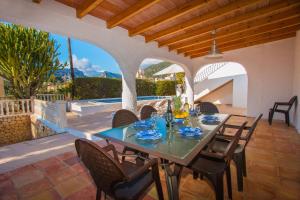 a dining table and chairs on a patio at Villa Ibiza - PlusHolidays in Calpe