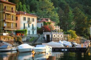 a group of boats docked in a marina with buildings at Ortensie & Oleandri al Lago - by MyHomeInComo in Argegno