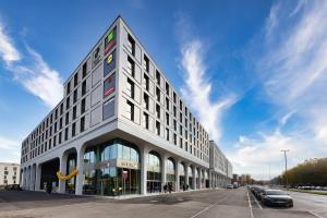 a large building on the corner of a street at ibis Styles Muenchen Perlach in Munich