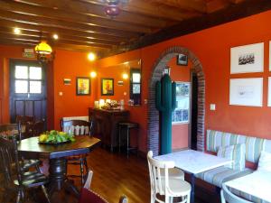 a restaurant with orange walls and a table and chairs at Posada Las Mañanitas in Cóbreces