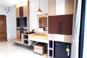 a kitchen with a desk and a tv in it at Avarin Resort in Pak Chong