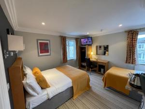 Habitación de hotel con cama y escritorio. en Shandon Hotel, en Richmond upon Thames
