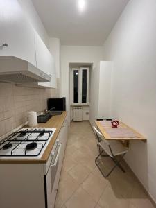 a kitchen with a stove and a table in it at Casa D'Arborea in Rome