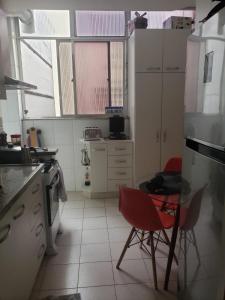 una cocina con 2 sillas rojas y una mesa en Lindo apartamento top Copacabana luxo, en Río de Janeiro