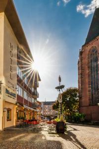 a street in a town with the sun in the sky w obiekcie Paulaner am Dom Hotel w Frankfurcie nad Menem