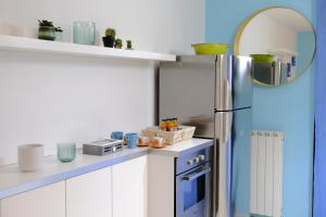 una cucina con frigorifero blu e armadietti bianchi di Light Blue House a Montesilvano