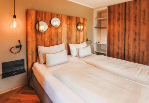 a bedroom with a large white bed with wood paneling at kh1897 I kirchenwirt hofer in Puch bei Weiz