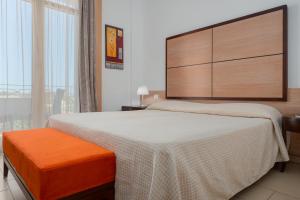 a bedroom with a large bed and a large window at The Pelican Beach Resort & SPA - Adults Only in Olbia