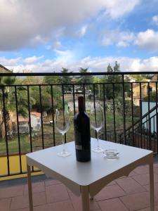 una bottiglia di vino seduta su un tavolo con bicchieri da vino di OPUNTIA DELL'ETNA BIKE HOUSE a Mascalucia