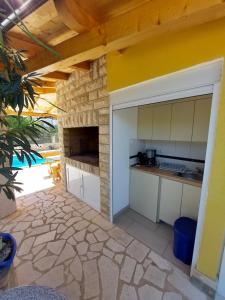 an outdoor kitchen with a counter and a stone wall at Pranjic Delux Guest House in Vodice