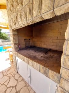 a stone oven in a patio with a pool at Pranjic Delux Guest House in Vodice