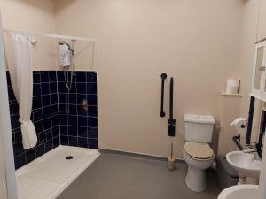 a bathroom with a toilet and a shower and a sink at Cripps Annexe in Nottingham