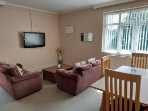 a living room with two couches and a tv at Cripps Annexe in Nottingham